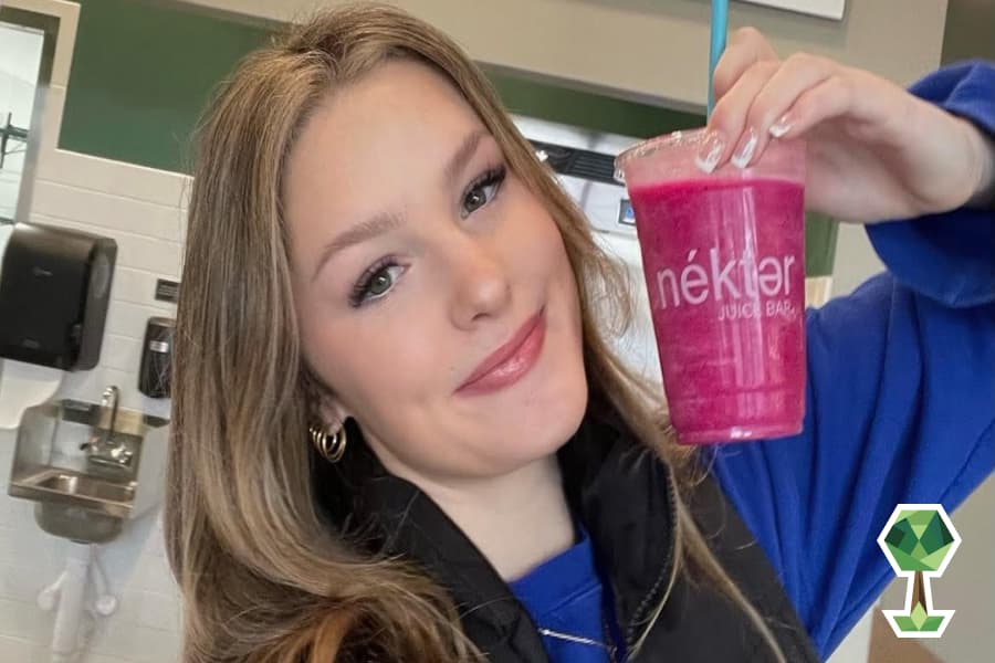 A woman holding a Nekter Smoothie