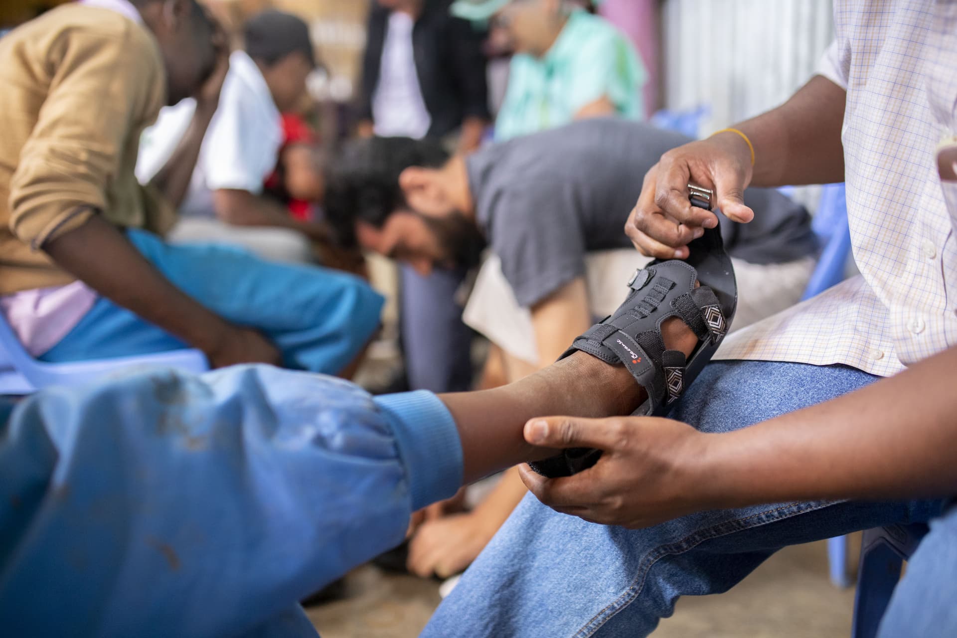 Person putting The Shoe That Grows on a child in need in Kenya | Because International
